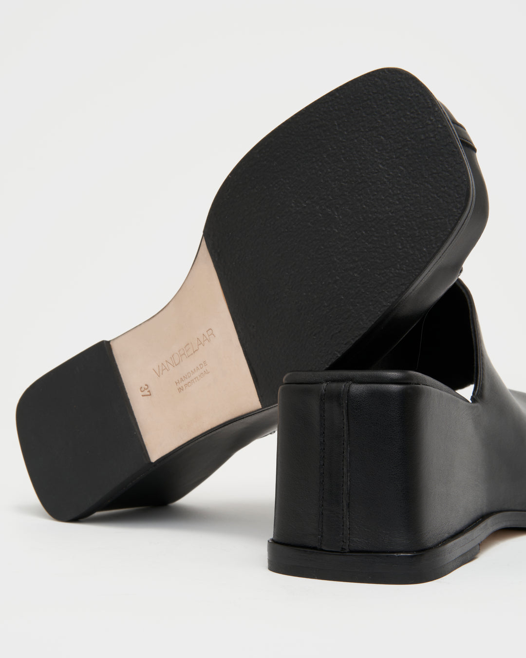 Women's wedge platform mule slide-on shoes made from buttery soft premium European black leather. The shoe design features a wholecut upper, meaning that it's been cut in one continuous piece. The toe and heel of the shoe are a chiseled square shape. The insole is fully padded for all-day comfort and the nubuck sole features non-slip rubber inserts. The perfect 90s inspired cool girl shoe for spring summer and fall.