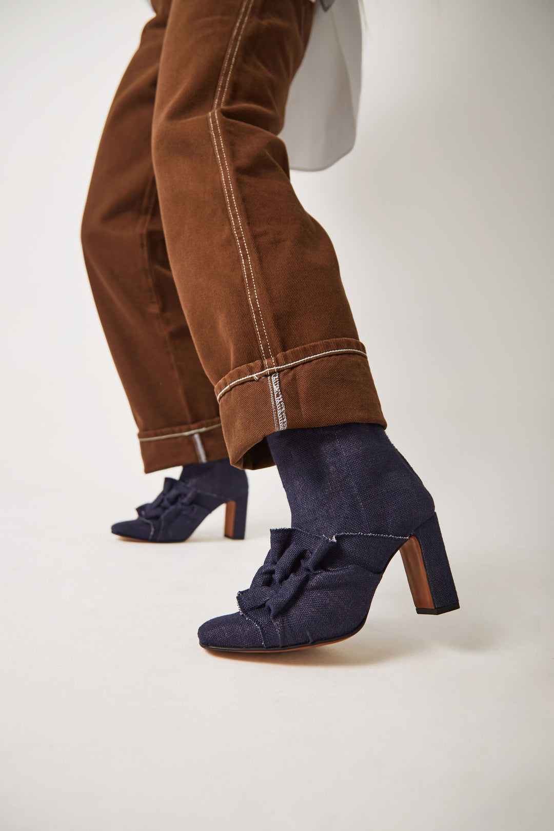 Women's navy blue vegan linen canvas fabric high heel boot with square chiseled toe. Ruffle Canadian smocking detailing on shoe. Sculptural silhouette boot for autumn fall winter season. Mid-calf high heel boots for women with a metal zipper at the back. Luxury shoes and boots made in Portugal.
