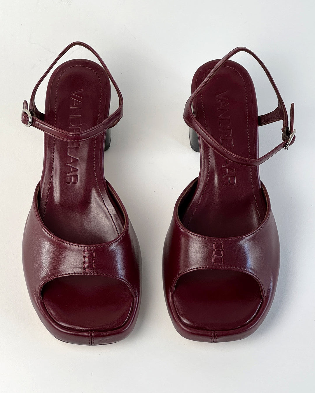 Women's mid-heel block heel open toe sandal with a concealed hidden platform of 2cm (3/4 inch) height and a stacked effect sturdy block heel of 6.5cm (2 3/4 inch) height. The elegant, minimal and timeless sandals comes with a dainty ankle strap that is elasticated to provide additional comfort. The insole is cut to a square toe shape and is fully padded for ultimate all-day comfort. This is the perfect 90's inspired cool girl sandal to wear all spring summer! Made from premium cherry burgundy leather.