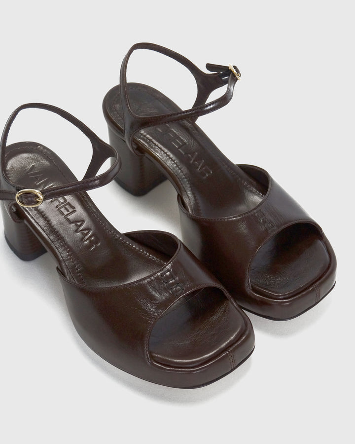 Women's mid-heel block heel open toe sandal with a concealed hidden platform of 2cm (3/4 inch) height and a stacked effect sturdy block heel of 6.5cm (2 3/4 inch) height. The elegant, minimal and timeless sandals comes with a dainty ankle strap that is elasticated to provide additional comfort. The insole is cut to a square toe shape and is fully padded for ultimate all-day comfort. This is the perfect 90's inspired cool girl sandal to wear all spring summer! Made from premium shiny espresso brown leather.