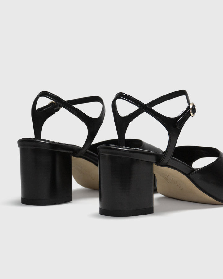 Women's mid-heel block heel open toe sandal with a concealed hidden platform of 2cm (3/4 inch) height and a stacked effect sturdy block heel of 6.5cm (2 3/4 inch) height. The elegant, minimal and timeless sandals comes with a dainty ankle strap that is elasticated to provide additional comfort. The insole is cut to a square toe shape and is fully padded for ultimate all-day comfort. This is the perfect 90's inspired cool girl sandal to wear all spring summer! Made from premium shiny black leather.
