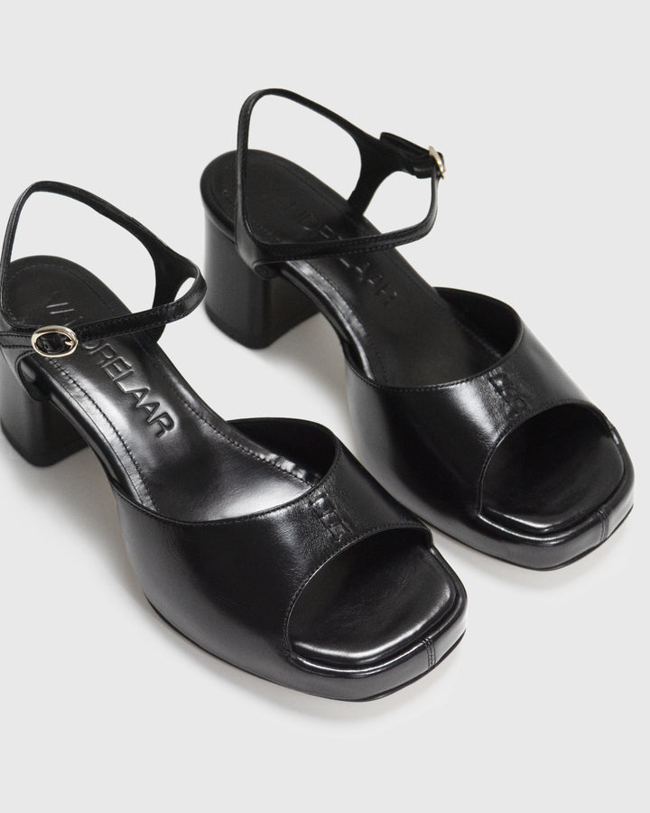 Women's mid-heel block heel open toe sandal with a concealed hidden platform of 2cm (3/4 inch) height and a stacked effect sturdy block heel of 6.5cm (2 3/4 inch) height. The elegant, minimal and timeless sandals comes with a dainty ankle strap that is elasticated to provide additional comfort. The insole is cut to a square toe shape and is fully padded for ultimate all-day comfort. This is the perfect 90's inspired cool girl sandal to wear all spring summer! Made from premium shiny black leather.